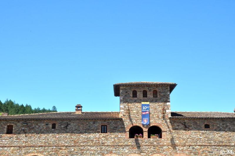 Castello Di Amorosa: каменная башня с флагом 10-й годовщины